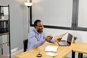 Man sitting at desk holding paper photo