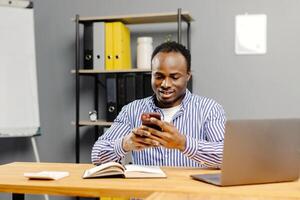 Man sitting at desk using mobile phone photo
