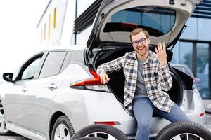 Car mechanic working in car showroom and changing wheel alloy tire. Repair or maintenance auto service. photo