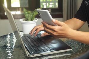 Someone is using mobile banking and a laptop photo