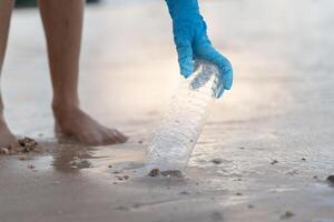 Save water. Volunteer pick up trash garbage at the beach and plastic bottles are difficult decompose prevent harm aquatic life. Earth, Environment, Greening planet, reduce global warming, Save world photo