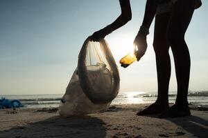 Save water. Volunteer pick up trash garbage at the beach and plastic bottles are difficult decompose prevent harm aquatic life. Earth, Environment, Greening planet, reduce global warming, Save world photo