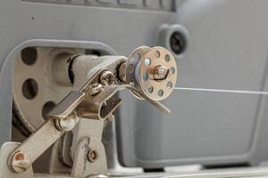 Details of a sewing machine, spool of thread photo