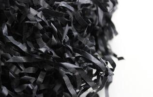 Intertwined strips of crumpled black wrapping paper isolated on white. Paper shavings for decoration stock photo
