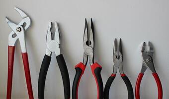 Different Types Of Pliers With Plastic Handles Arranged By Size Isolated On White Background photo
