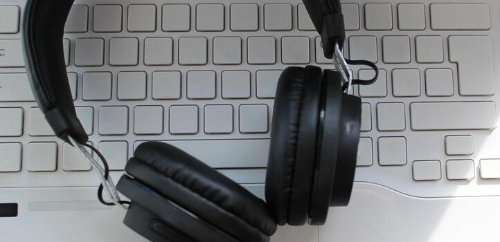 Black Headphones On White Blank Keys Of Computer Keyboard photo