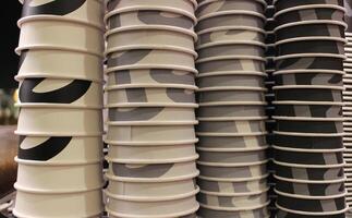 Coffee Intensity Image Concept. Kraft Cardboard Cups For Coffee Stacked In Color From White To Black photo