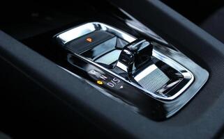 Illuminated symbols of the activated parking brake and neutral gear on the transmission selector in sports car closeup view photo