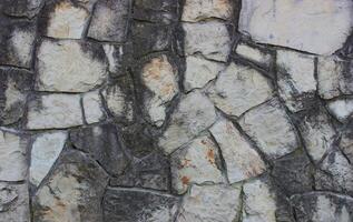 Granite stones darkened with time and placed in old masonry photo