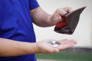 Poor man hold leather wallet with some coins. Concept bad economy, financial crisis, risk on the end of month. Finance management. Pay day. Debt. Broke. Bankrupt. Financial problems. photo
