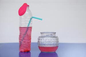 Bottle with red water ink with flat pink balloon on the top, straw tube and glass jar. Concept, Equipment for doing fun science experiment for kid learning. teaching aids, educational materials. photo