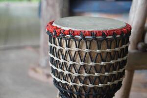 Folklore drum, decorated with rope knots net. Concept, musical instrument. Beat drum with rhythm along music and songs for entertainment. Vintage and traditional style. Hand drum. photo