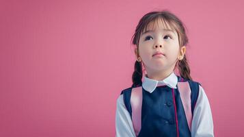 A little girl dressed in school uniform, blank pastel background photo