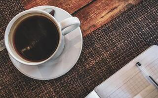 Cup of coffee with notepad and ballpoint pen on table Mexico. photo