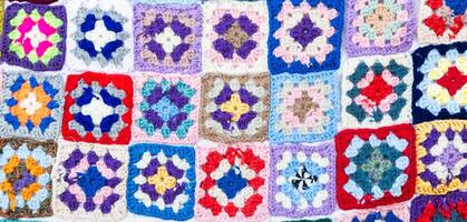 Multi colored blanket in wool, square geometric background, retro decorative pattern photo