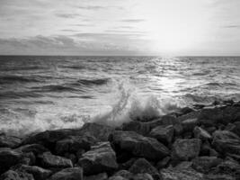 Beautiful sea waves with foam and sky, front view. Monochrome image photo
