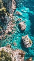 A stunning view of clear turquoise water crashing against rocky cliffs photo