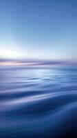 Blurry waves and a soft sunset sky merge into a calming gradient photo