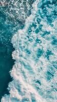 A beautiful blue wave with white foam crashing in the ocean photo