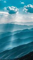 Sunbeams pierce through clouds and illuminate misty mountain ranges photo
