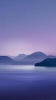 A calm lake with mountains reflected in the water photo