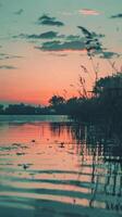A tranquil scene of a sunset reflecting in a calm body of water photo