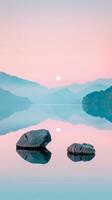 Two rocks on a still lake reflect sunrise light photo