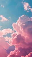 Pink clouds float against a clear blue sky photo