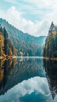 Peaceful lake reflecting a forested mountain range photo