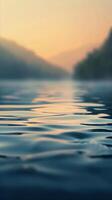 A close-up of rippling water, reflecting the soft glow of a setting sun photo
