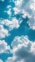 Clouds float majestically against a clear, bright blue sky photo