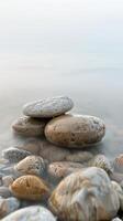 Smooth, wet stones on the edge of a tranquil lake photo