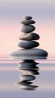Stones stacked in perfect balance reflect on calm water photo