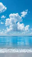Serene beach with calm, crystal-clear water and puffy clouds overhead photo