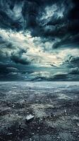 A stormy sky with dark, brooding clouds hangs over a barren, cracked earth photo