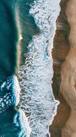 Turquoise ocean waves breaking on a sandy beach photo