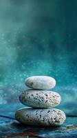 Stack of smooth stones against a blue, green, and white background photo