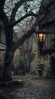 A tree stands tall in the center, with gas lamps illuminating a cobblestone street photo