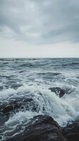 Waves break on the rocky shore, creating a dramatic scene photo