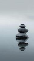 Balanced stones on a lake, creating a serene reflection photo