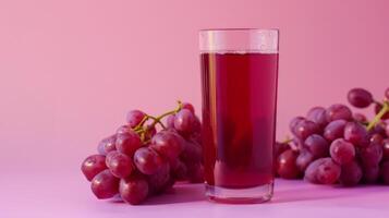 A glass of grape juice with grapes beside it photo