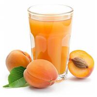 A glass of apricot nectar with ripe apricots and a green leaf photo