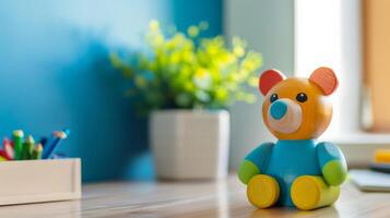 A colorful wooden bear toy sits on a desk with empty space beside it photo