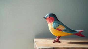 A hand-painted wooden swallow toy sits on a desk, its wings poised for takeoff photo