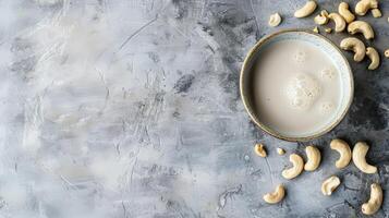 Cashew milk in a bowl with scattered cashews photo
