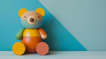 A colorful wooden bear toy sits on a desk photo