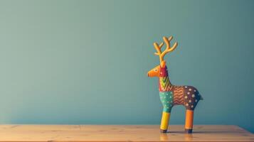 A colorful wooden deer toy stands on a wooden desk photo