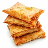 A close-up of four golden brown phyllo pastries, stacked neatly photo
