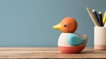 A colorful wooden duck toy sits on a desk, with empty space for writing or drawing photo