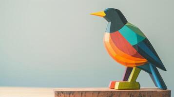 A bright, colorful wooden crow toy stands on a desk, facing to the right photo